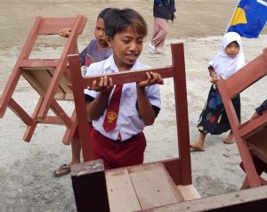 adik-adik ikut membantu memindahkan kursi dan meja belajar untuk ruang kelas mereka.